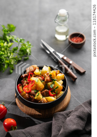 Fried pork meat with potatoes, onions and peppers. National homemade Georgian dish ojakhuri Fried pork meat with potatoes, onions and peppers. National homemade Georgian dish ojakhuri 118174426