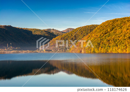 mountain landscape at the lake in autumn. trees in colorful foliage on the shore. beautiful nature view on a sunny morning. scenery reflecting on the rippled water surface mountain landscape at the lake in autumn. trees in colorful foliage on the shore. beautiful nature view on a sunny morning. scenery reflecting on the rippled water surface 118174626