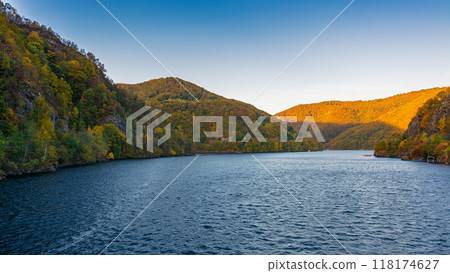 mountain landscape at the lake in autumn. trees in colorful foliage on the shore. beautiful nature view on a sunny morning. scenery in carpathian mountains of romania 118174627