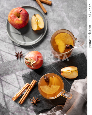 Homemade apple punch with fresh apples, cinnamon and spices in cups on dark background Homemade apple punch with fresh apples, cinnamon and spices in cups on dark background 118174656