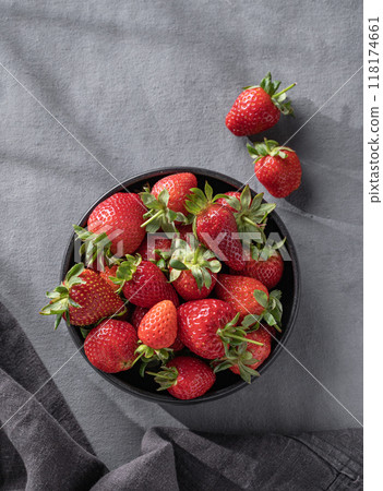 Juicy strawberries in a black bowl on a dark background with napkin. Farm ripe healthy berries Juicy strawberries in a black bowl on a dark background with napkin. Farm ripe healthy berries 118174661
