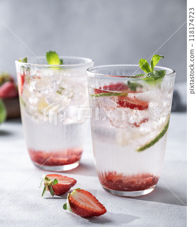 Fresh strawberry mojito in a glass with berries, lime, mint and ice on a light background.  118174723