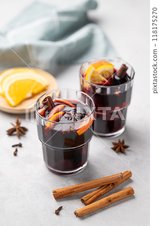 Mulled wine with orange, apple and cinnamon in glasses on a light background.  118175270