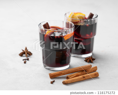 Mulled wine with orange, apple and cinnamon in glasses on a light background. Mulled wine with orange, apple and cinnamon in glasses on a light background. 118175272