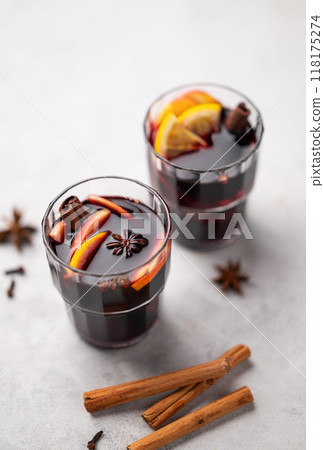 Mulled wine with orange, apple and cinnamon in glasses on a light background. Mulled wine with orange, apple and cinnamon in glasses on a light background. 118175274