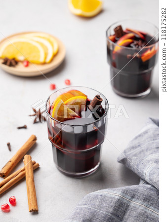 Mulled wine with orange, apple and cinnamon in glasses on a light background.  118175282