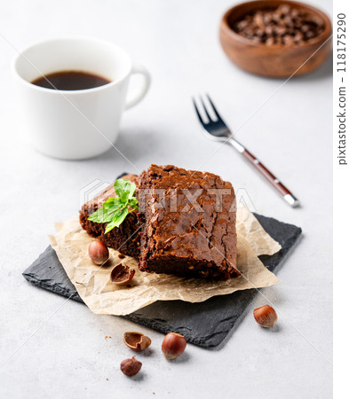 Pieces of chocolate brownies with hazelnuts, mint and salted caramel on baking paper  118175290