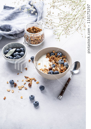 The concept of a healthy breakfast of yogurt, granola and fresh blueberry on a light background  118175297