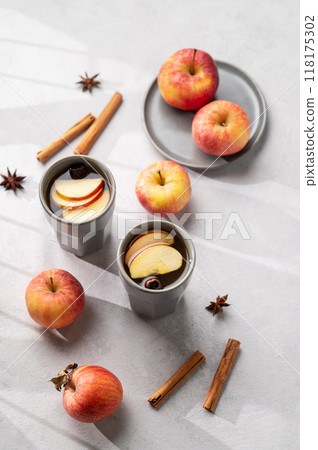 Homemade apple punch with apples and cinnamon in cups on a light background with fresh fruits 118175302