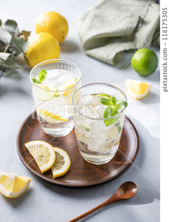 Lemonade drink with fresh lemon, lime, mint and ice. Refreshing citrus mojito cocktail Lemonade drink with fresh lemon, lime, mint and ice. Refreshing citrus mojito cocktail 118175305