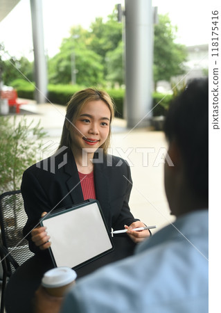 Businesspeople using digital tablet and discussing business project at an outdoor cafe 118175416