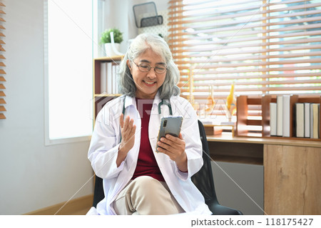 Senior doctor making online telemedicine video call consultation with patient on her mobile phone Senior doctor making online telemedicine video call consultation with patient on her mobile phone 118175427