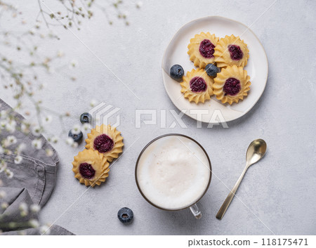 Cappuccino or latte with milk foam in a cup with handmade berry cookies and blueberries Cappuccino or latte with milk foam in a cup with handmade berry cookies and blueberries 118175471