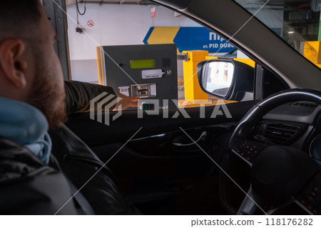 Driver Using Payment Machine at Parking Facility Driver Using Payment Machine at Parking Facility 118176282