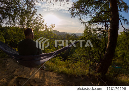 Relaxing in a Hammock at Sunset Relaxing in a Hammock at Sunset 118176296