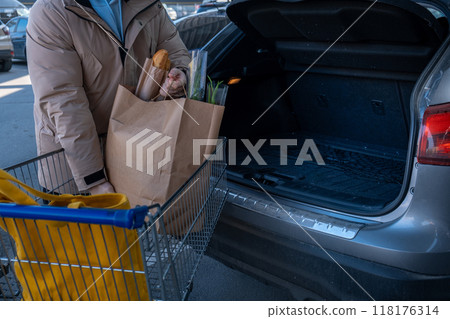 Man Loading Groceries into Car Trunk Man Loading Groceries into Car Trunk 118176314