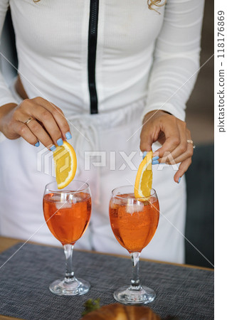 Close-up of attractive curly hair girl preparing cocktail at home. Food and drinks on wooden table Close-up of attractive curly hair girl preparing cocktail at home. Food and drinks on wooden table 118176869