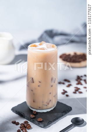 Iced coffee latte in a tall glass with milk on a blue background with coffee beans Iced coffee latte in a tall glass with milk on a blue background with coffee beans 118177827