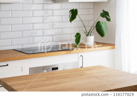 Wooden tabletop with free space for product montage or mockup against blurred white kitchen  118177829
