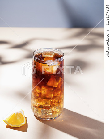 Long Island iced tea cocktail with hard liquor with rum, cola, lemon and ice on yellow background 118177834