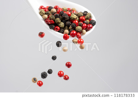Different types of peppercorns pouring. Red, green, white and black pepper. Different types of peppercorns pouring. Red, green, white and black pepper. 118178333