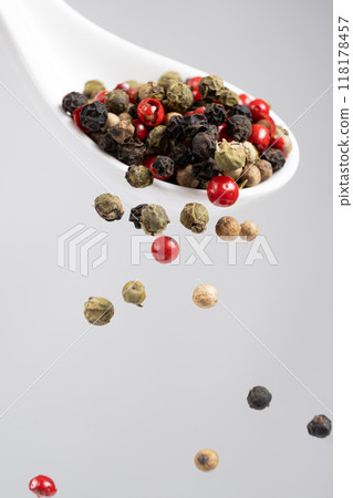 Different types of peppercorns pouring. Red, green, white and black pepper. 118178457