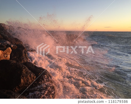 Waves crash against the rocky shore 118179386