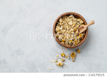 Dried chamomile in a wooden bowl. Healthy food and drink concept. Herbal and alternative medicine Dried chamomile in a wooden bowl. Healthy food and drink concept. Herbal and alternative medicine 118179525