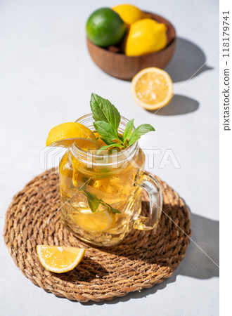 Lemonade drink or cold tea with fresh lemon, mint and ice in jar. Refreshing citrus mojito cocktail Lemonade drink or cold tea with fresh lemon, mint and ice in jar. Refreshing citrus mojito cocktail 118179741