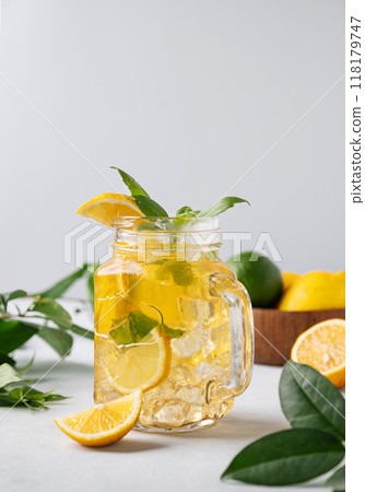 Lemonade drink or cold tea with fresh lemon, mint and ice in jar. Refreshing citrus mojito cocktail Lemonade drink or cold tea with fresh lemon, mint and ice in jar. Refreshing citrus mojito cocktail 118179747