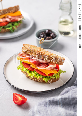 Toast club sandwich made of grain bread with cheddar cheese and bacon stuffed with tomatoes Toast club sandwich made of grain bread with cheddar cheese and bacon stuffed with tomatoes 118179771