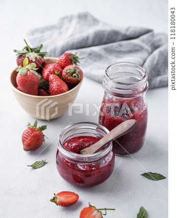 Strawberry jam in a jar on a light background with fresh berries. The concept of homemade delicious 118180043