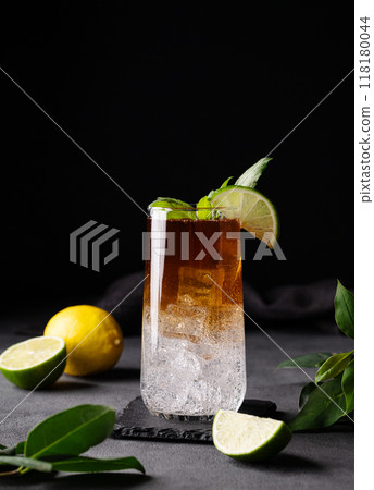 Coffee brew with tonic, ice and lime in a tall glass on a dark background with citrus fruit 118180044