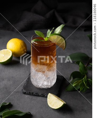 Coffee brew with tonic, ice and lime in a tall glass on a dark background with citrus fruit  118180046