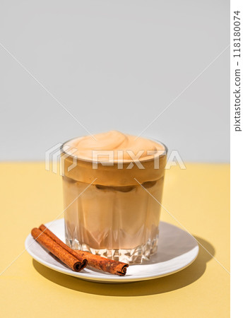 Dalgona coffee. Whipped instant iced coffee in a glass with cinnamon sticks 118180074