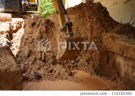 A significant pile of ground is being excavated by a bulldozer 118180360