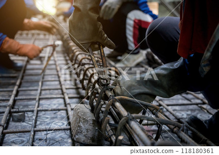 A group of builders is busy constructing a metal structure A group of builders is busy constructing a metal structure 118180361