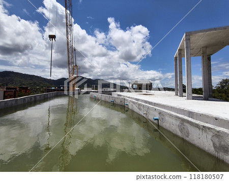 Large building with a roof pool of water under construction 118180507