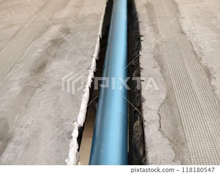 A bright blue pipes attached to a solid concrete wall 118180547