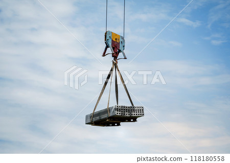 Heavy construction load being lifted by a tall crane Heavy construction load being lifted by a tall crane 118180558