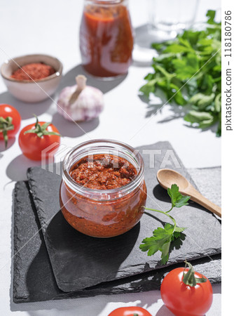 Homemade tomato sauce is an appetizer with tomatoes and hot peppers in a jar on a slate  Homemade tomato sauce is an appetizer with tomatoes and hot peppers in a jar on a slate  118180786