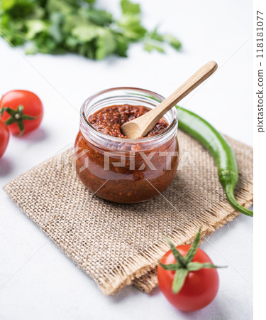 Homemade adjika sauce is an appetizer with tomatoes and hot peppers in a jar  118181077