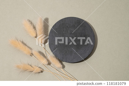 Round empty slate board on a green background with golden branches. Round empty slate board on a green background with golden branches. 118181079