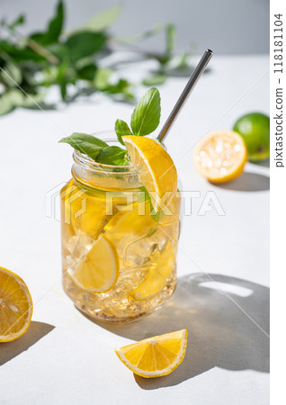 Lemonade drink or cold tea with fresh lemon, mint and ice in jar. Refreshing citrus mojito cocktail Lemonade drink or cold tea with fresh lemon, mint and ice in jar. Refreshing citrus mojito cocktail 118181104