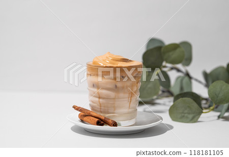 Whipped Dalgona coffee with soy milk. Instant cold coffee with ice in a glass with cinnamon sticks Whipped Dalgona coffee with soy milk. Instant cold coffee with ice in a glass with cinnamon sticks 118181105
