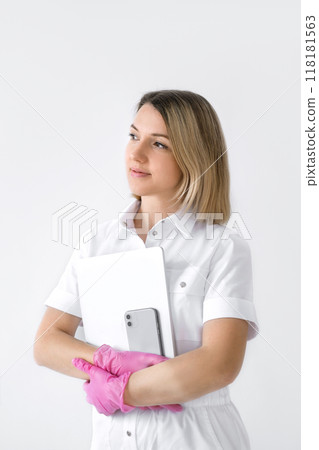A female doctor in pink gloves holds a phone and laptop in her hands A female doctor in pink gloves holds a phone and laptop in her hands 118181563