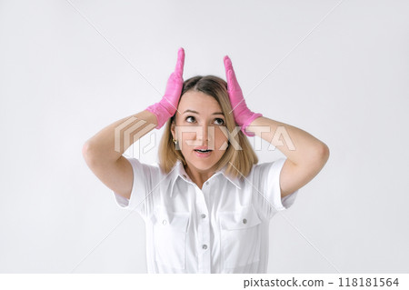 A female doctor in pink gloves holds her head in horror. 118181564