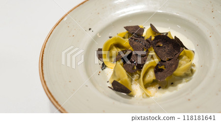 Tortelli funghi e tartufo. Handmade cappelletti, mushroom truffle filling served with parmesan cream and fresh winter truffle. Pasta plate in Italian Osteria Restaurant. 118181641