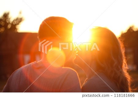 A heartwarming image of a couple's silhouettes against a vibrant sun setting or rising in the background. The scene conveys themes of love, hope, and happiness. Blurred, out of focus A heartwarming image of a couple's silhouettes against a vibrant sun setting or rising in the background. The scene conveys themes of love, hope, and happiness. Blurred, out of focus 118181666