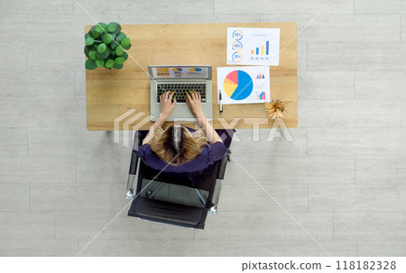 Professional woman analyzing data at a modern workplace with laptop computer. Top view 118182328